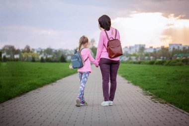 Anne ve yaz günü yürüyüş sırt çantası ile onun küçük dauther. Bir arkadan görüntülemek.