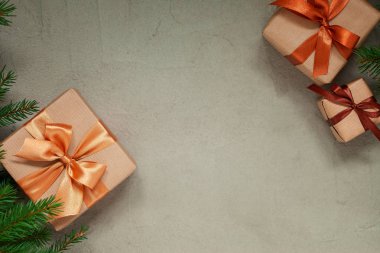 Noel kompozisyonu. Tarafsız gri arka planda üç mevcut kutu ve noel ağacı var. Tatil kavramı.