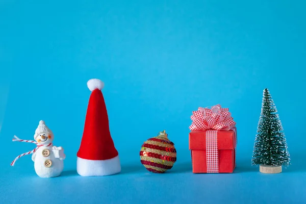 Karácsonyi ünnep ünnep koncepció karácsonyfa és labda, Santa Hat, ajándék doboz, hóember. — Stock Fotó