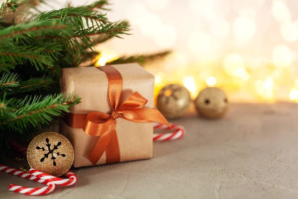 圣诞礼物或礼品盒包装的工艺品，带有冷杉枝条和节日装饰的浅褐色背景 — 图库照片