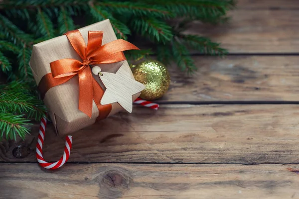 Vánoční ozdoby. Dárkové balení řemesla s jedlovými větvemi a rekreační dekorace na dřevěném pozadí. — Stock fotografie
