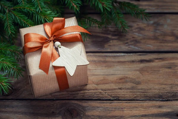 圣诞装饰品 带有冷杉枝条和木制背景假日装饰的礼品包装工艺品. — 图库照片