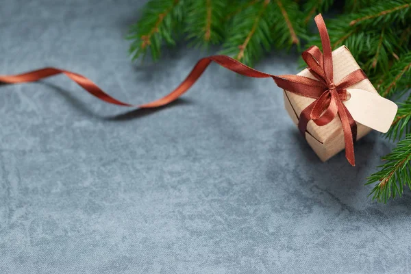Різдвяна подарункова коробка і коричнева стрічка з міткою на темному фоні з простором . — стокове фото