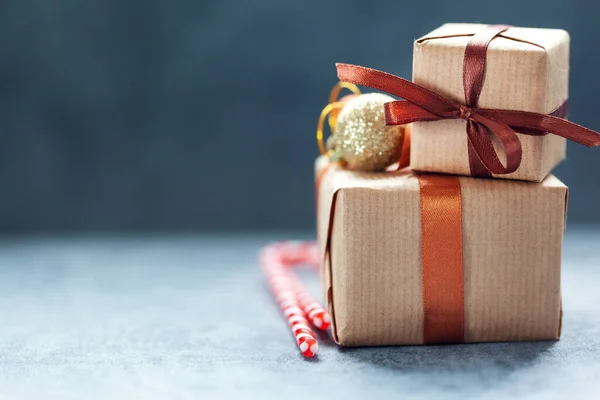 Маленькие подарочные коробочки ручной работы с рождественскими украшениями на темном фоне — стоковое фото