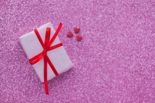 Подарункова коробка з червоними та білими серцями на фоні рожевого блискучого Валентина концепція дня . — стокове фото