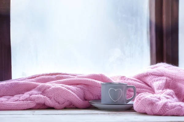 Bir fincan çay, kahve, çikolata ve sisli pencerede pembe ekose.