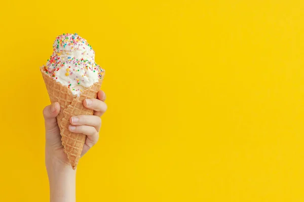 Çocukların elinde harika vanilyalı dondurma külahı var. Parlak sarı bir zemin üzerinde ve fotokopi alanı var..