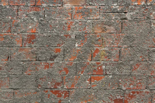 Mur z cegły częściowo pokryte z cementu. — Zdjęcie stockowe