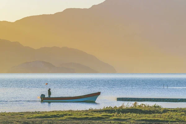 湖、プエルトアイセン、チリにある小さなボートで男 — ストック写真