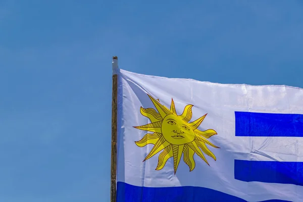 Bandeira uruguaia sobre fundo azul do céu — Fotografia de Stock