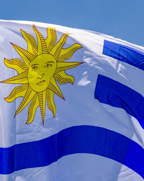 Bandeira uruguaia sobre fundo azul do céu — Fotografia de Stock