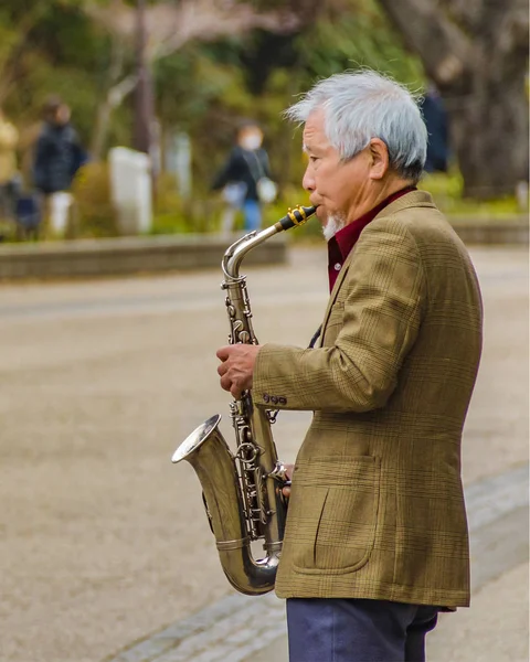 일본 도쿄에 있는 공원에서 색소폰을 연주하고 있는 노인 — 스톡 사진