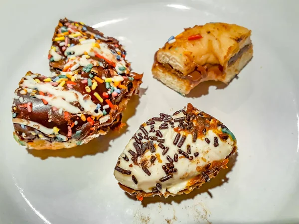 Donuts meio comido no prato branco — Fotografia de Stock