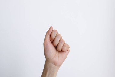 Beyaz arka plandaki kadın eli gündüz hareketlerini gösteriyor.