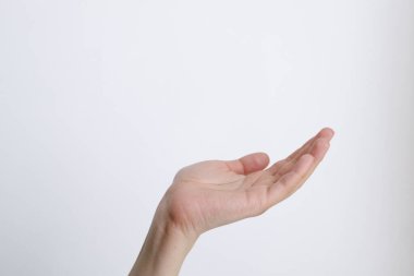 Beyaz arka plandaki kadın eli gündüz hareketlerini gösteriyor.