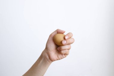 Gündüz vakti beyaz bir arka planda tavuk yumurtası olan bir kadın.