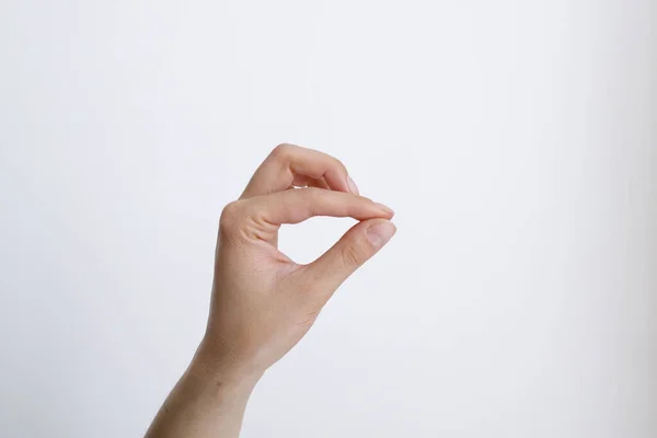 Beyaz arka plandaki kadın eli gündüz hareketlerini gösteriyor.