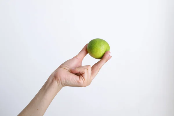 Gündüz vakti beyaz bir arka planda limonlu bir kadın.