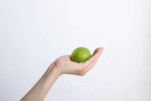 Gündüz vakti beyaz bir arka planda limonlu bir kadın.
