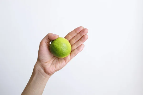 Gündüz vakti beyaz bir arka planda limonlu bir kadın.