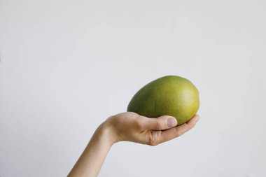 Gündüz vakti beyaz arka planda yeşil mangolu bir kadın.