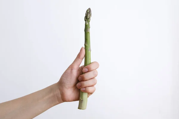 Vrouwelijke Hand Met Groene Asperges Een Witte Achtergrond Bij Daglicht — Stockfoto