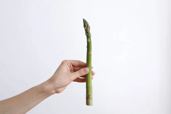 Vrouwelijke Hand Met Groene Asperges Een Witte Achtergrond Bij Daglicht — Stockfoto