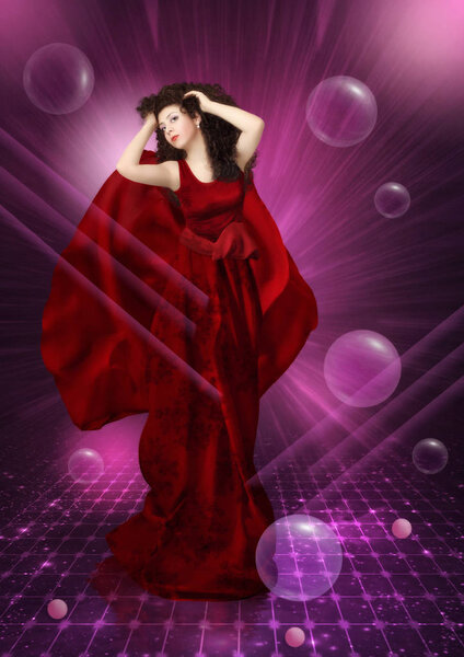 A young girl with a dreamy look and long curly hair in a red dress on an abstract cosmic background