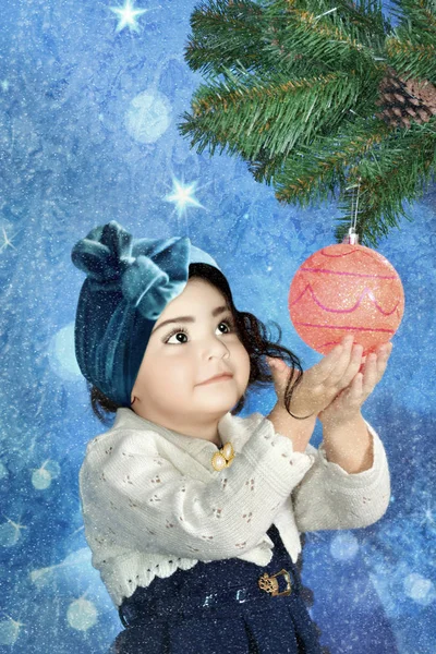 Dziewczynka Wygląda Zafascynowaną Świątecznym Balem Gałązce Jodły Szyszką — Zdjęcie stockowe