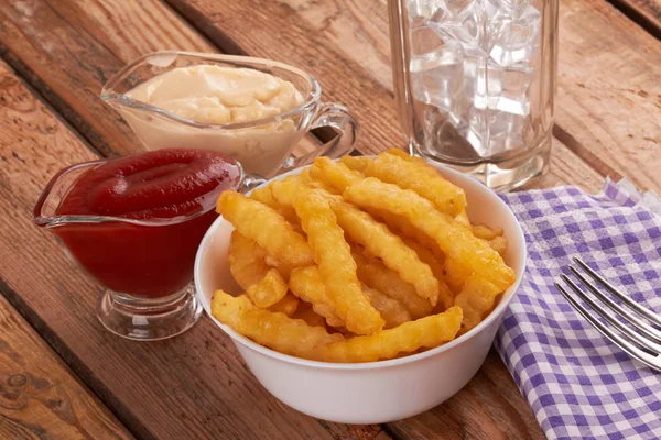 Papas fritas sobre mesa de madera —  Fotos de Stock