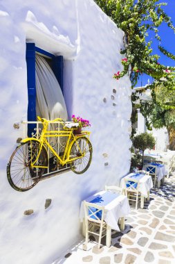 Eski bisiklet Naxos Adası ile süslenmiş dar sokaktaki büyüleyici Yunan meyhaneleri.