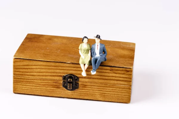 Toy models of old couple sitting on wooden box — Stock Photo, Image