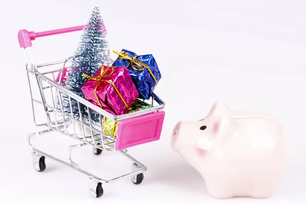 Shopping cart with christmas tree, gifts and pig money box — Stock Photo, Image