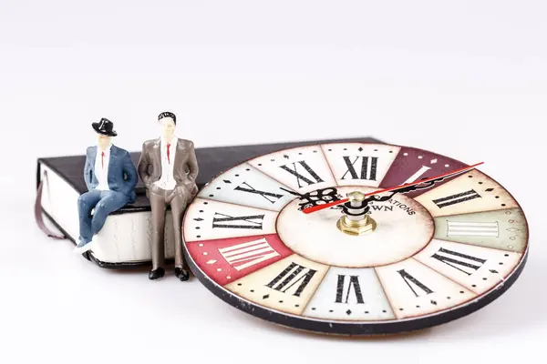 Modell eines Mannes, der auf einem Organisator oder Planer mit alter Uhr sitzt — Stockfoto