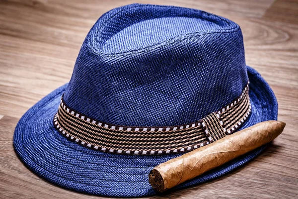青い帽子と木製の床、煙概念で葉巻 — ストック写真