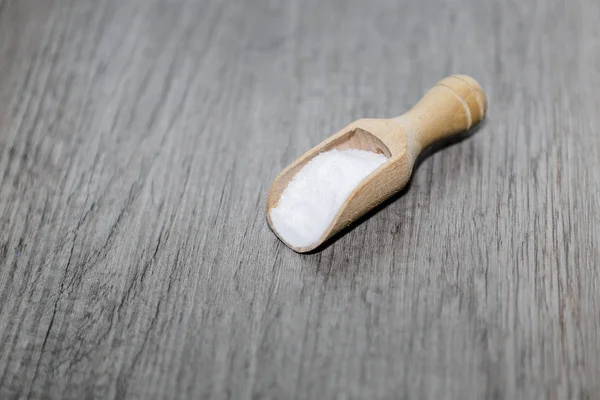 Witte zout in houten lepel op de tabel of de oude vloer — Stockfoto