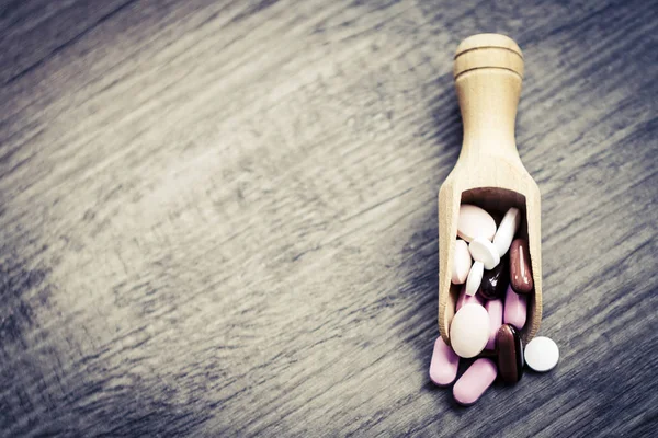 Pillen in de lepel op de houten vloer — Stockfoto