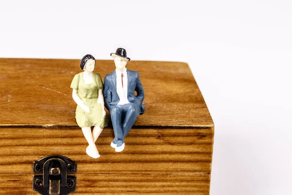 Toy models of old couple sitting on wooden box — Stock Photo, Image