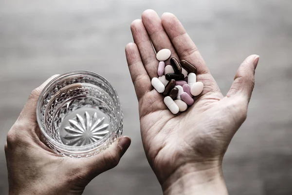 Verre d'eau et de pilules dans les mains de la femme, toxicomanie — Photo