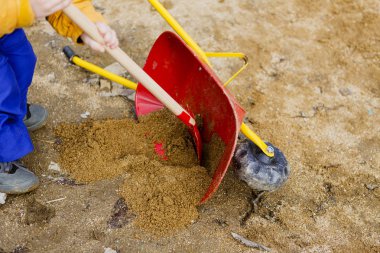 Çocuk oyun kumla, kırmızı kürek ve küçük şirin barrow