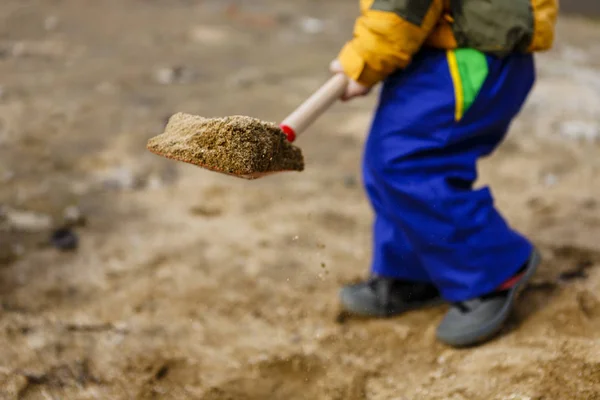 Barn leka med sand och röd spade — Stockfoto