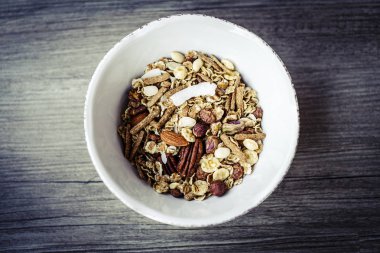 sağlıklı kahvaltı için hazırlanmış ahşap masa üzerinde müsli ile kase