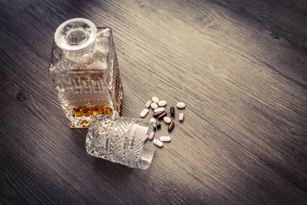 Bottle with alcohol and pills — Stock Photo, Image