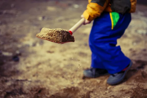 Child play with sand and red shovel — Stock Photo, Image