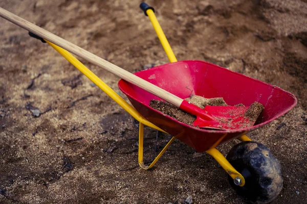 Kleine Schubkarre oder Schubkarre mit Sand - Spielplatz — Stockfoto