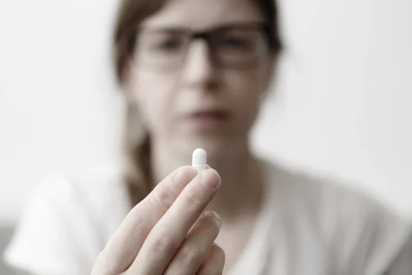 Yound женщина ест таблетки или витамин — стоковое фото