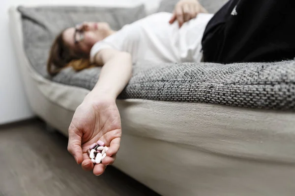 dead woman lie on sofa after she eat drugs or pills