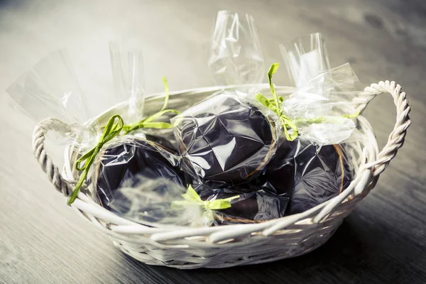 Ovos de Páscoa de chocolate e gengibre em sacos de plástico e fita verde Fotografias De Stock Royalty-Free