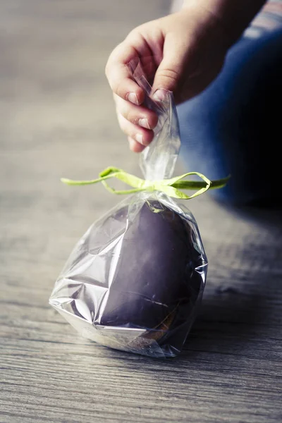 Chocholate and gingerbread easter egg in plastic bags and green ribbon — Stock Photo, Image