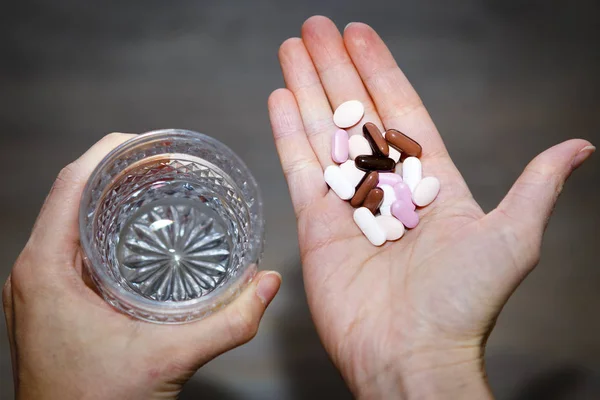 Verre d'eau et de pilules dans les mains de la femme, toxicomanie — Photo